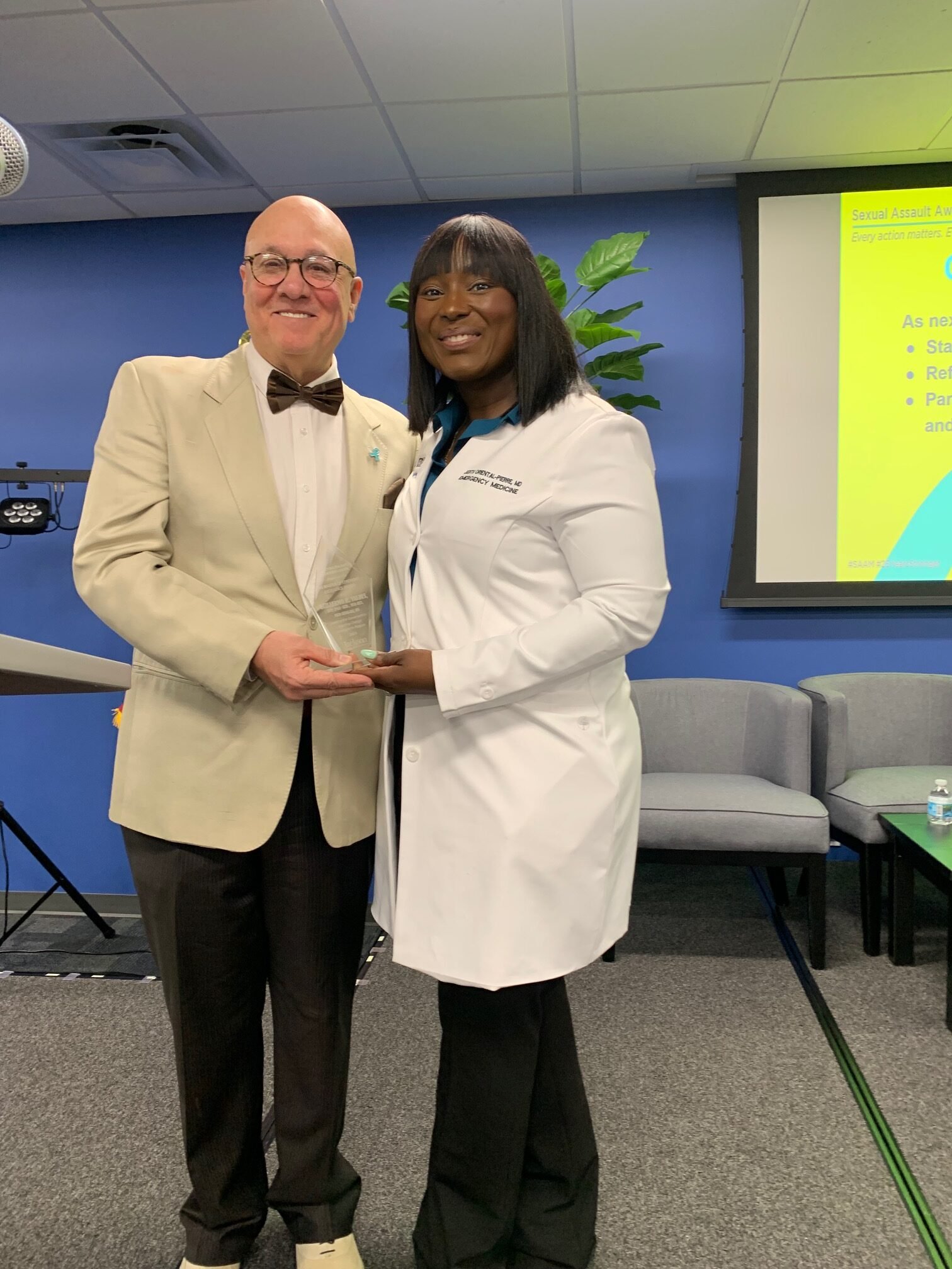 Dr. Judith Oriental-Pierre, MD presenting an award at the Sexual Assault Awareness Month Symposium